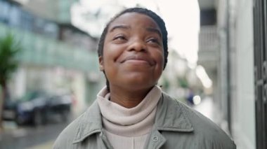 Sokakta kendine güvenen Afrikalı Amerikalı kadın gülümsüyor
