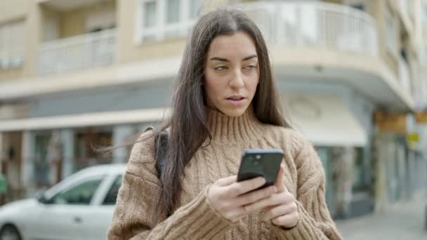 Mujer Hispana Hermosa Joven Usando Teléfono Inteligente Con Expresión Seria — Vídeo de stock