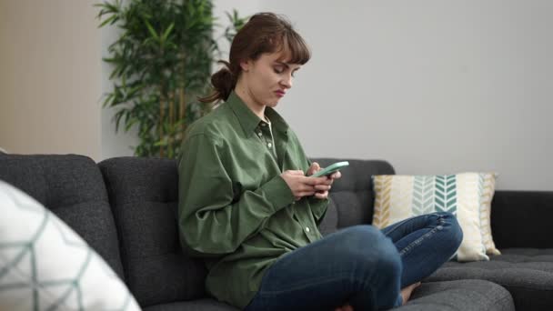 Mujer Joven Caucásica Usando Teléfono Inteligente Con Expresión Repugnante Casa — Vídeos de Stock