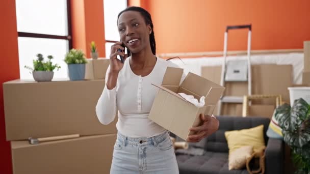 Африканська Американка Розмовляє Смартфоні Тримаючи Пакет Себе Вдома — стокове відео