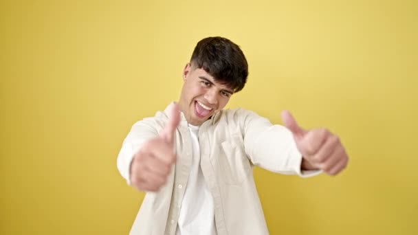 Ung Latinamerikansk Man Ler Med Tummen Upp Över Isolerad Gul — Stockvideo