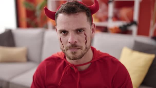 Young Caucasian Man Screaming Wearing Devil Costume Sitting Sofa Home — Vídeos de Stock