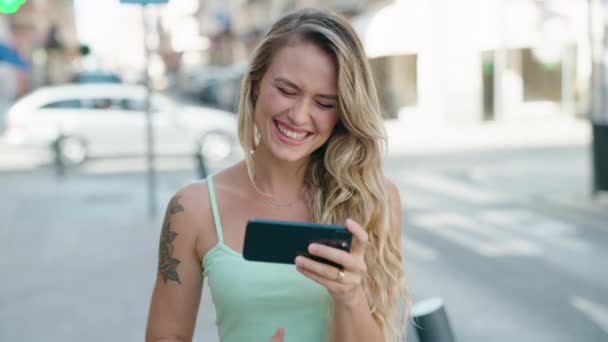 Mujer Rubia Joven Sonriendo Confiado Viendo Vídeo Teléfono Inteligente Calle — Vídeo de stock