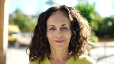 Orta yaşlı İspanyol kadın sokakta kendine güvenen gülümsüyor