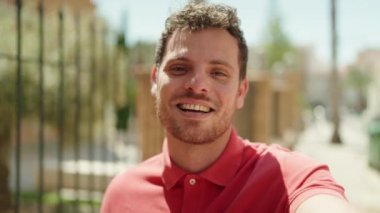 Latin asıllı genç adam gülümsüyor.