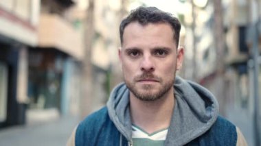 Sokakta kendinden emin gülümseyen beyaz bir genç.