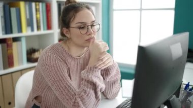 Young beautiful hispanic woman student using computer studying at library university