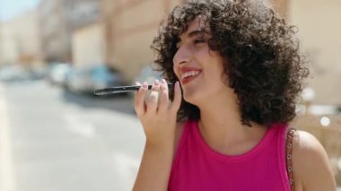 Young middle eastern woman smiling confident talking on the smartphone at street