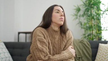 Evdeki kanepede oturan genç ve güzel İspanyol kadın stresli.