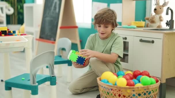 Uroczy Biały Chłopiec Uśmiecha Się Pewnie Bawiąc Się Zabawką Przedszkolu — Wideo stockowe