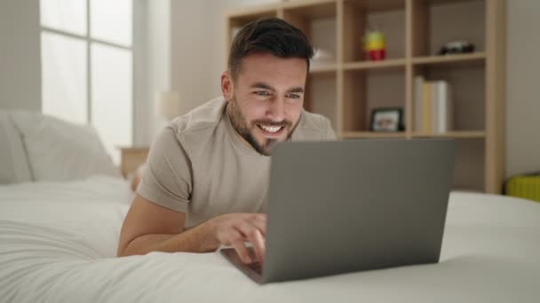 Jonge Spaanse Man Met Behulp Van Laptop Liggend Bed Slaapkamer — Stockvideo