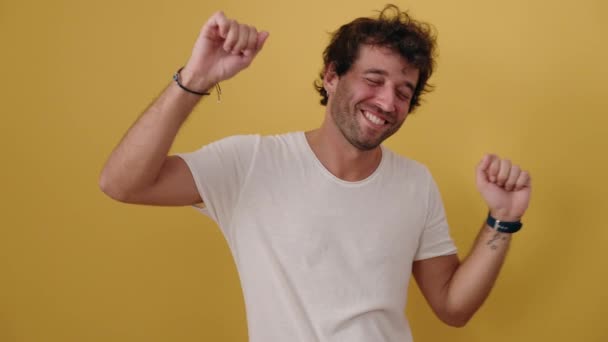 Jonge Latino Man Glimlachen Zelfverzekerd Dansen Geïsoleerde Gele Achtergrond — Stockvideo