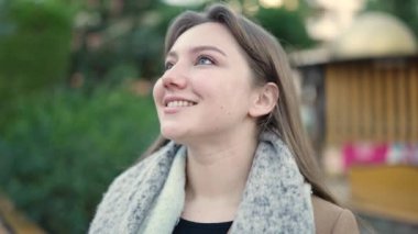 Parkta kendinden emin gülümseyen genç sarışın kadın.