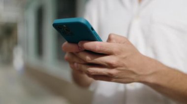 Sokakta akıllı telefon kullanan genç bir Arap.