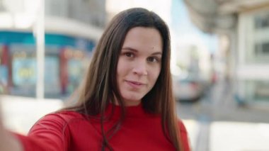 Gülümseyen genç bir kadın sokağın kamerasında özçekim yapıyor.