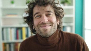 Young hispanic man student smiling confident standing at library university