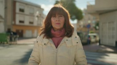Middle age redhead woman smiling confident standing at street