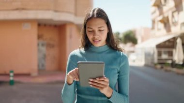 Sokakta dokunmatik ped kullanan, kendine güvenen genç Afro-Amerikan kadın.