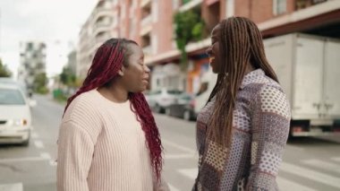 Two african american women smiling confident speaking at street
