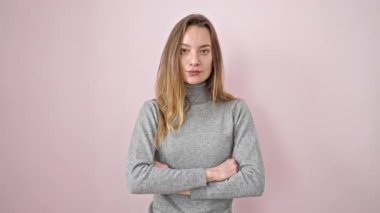 İzole edilmiş pembe arka planda sürpriz bir ifadeyle duran beyaz bir kadın.