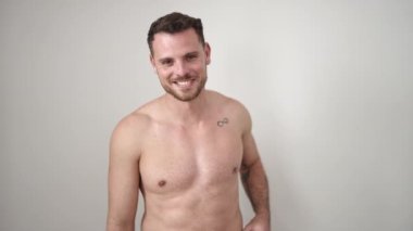 Young caucasian man standing shirtless smiling over isolated white background