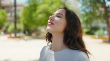 Young woman smiling confident breathing at park