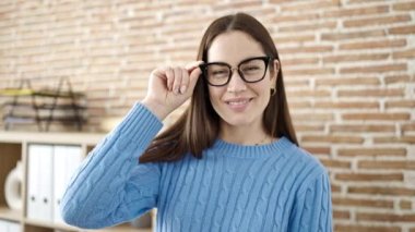 Kafkasyalı genç bir iş kadını ofiste kendinden emin gülümsüyor.