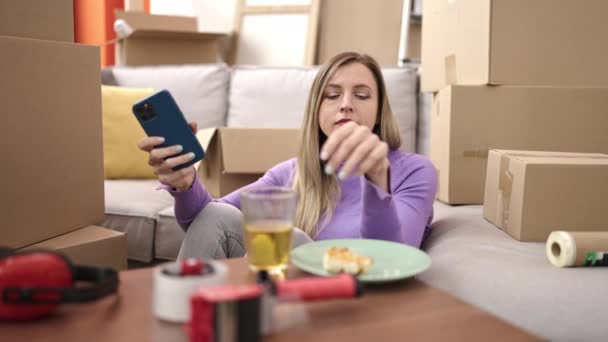 Ung Blond Kvinna Med Smartphone Äter Frukost Nytt Hem — Stockvideo