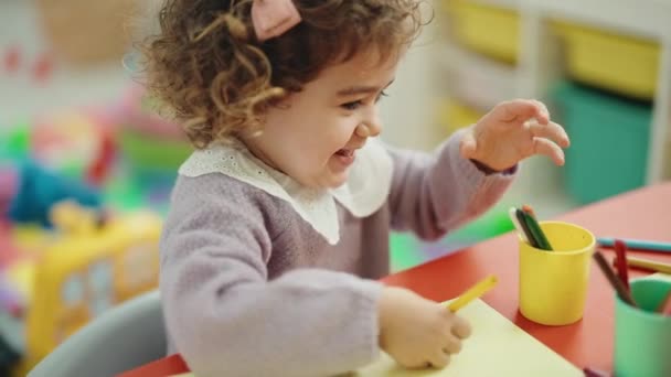 Entzückende Hispanische Vorschulschülerin Sitzt Kindergarten Auf Einem Tisch Und Zeichnet — Stockvideo
