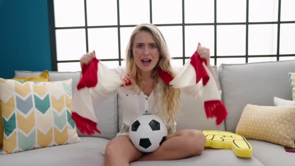 Young Blonde Woman Supporting Soccer Team Sitting Sofa Home — Vídeo de Stock