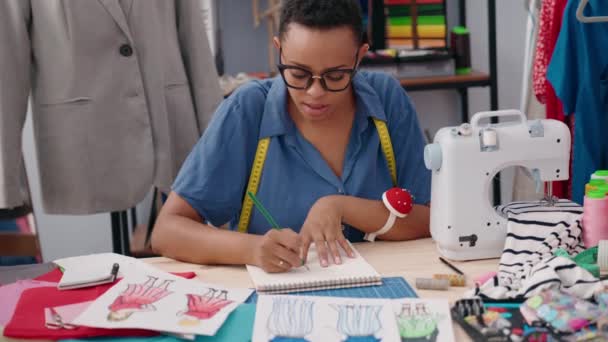 在裁缝店 非洲裔美国妇女裁缝在笔记本上画画 — 图库视频影像