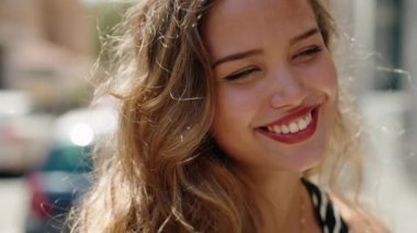Young beautiful hispanic woman smiling confident looking to the side at street