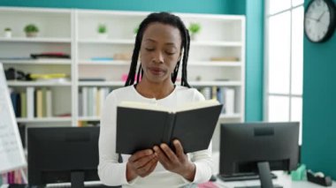 Üniversite sınıfında kitap okuyan Afrikalı Amerikalı kadın öğrenci.