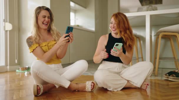 Two Women Using Smartphones Sitting Floor Home — Vídeo de Stock