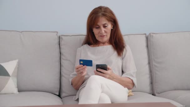 Žena Středního Věku Pomocí Smartphone Kreditní Karty Sedí Pohovce Doma — Stock video