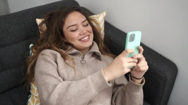 Jonge Mooie Spaanse Vrouw Met Behulp Van Smartphone Liggend Bank — Stockvideo