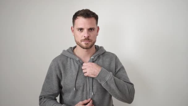 Young Caucasian Man Standing Serious Expression Taking Sweatshirt Isolated White — 图库视频影像