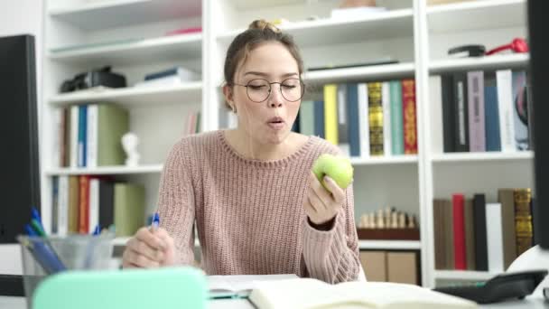 Joven Hermosa Estudiante Hispana Escribiendo Cuaderno Comiendo Manzana Universidad Biblioteca — Vídeo de stock