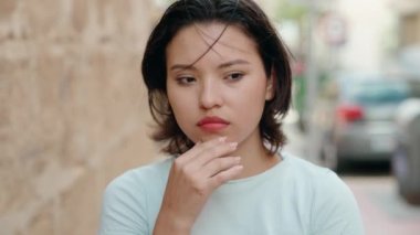 Sokakta şüpheli bir ifadeyle duran genç İspanyol kadın.