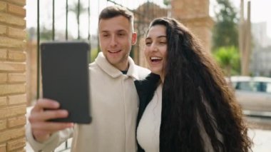 Young couple smiling confident having video call at street