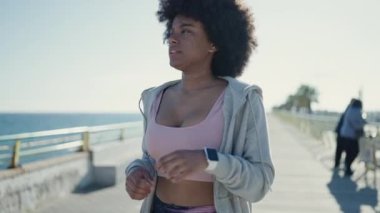 Deniz kenarında kronometre kullanan Afrikalı Amerikalı kadın.