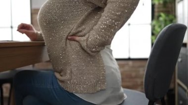 Middle age woman with grey hair business worker suffering for backache at office