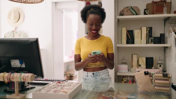 Giysi Mağazasında Bilgisayar Akıllı Telefon Kullanan Afrikalı Amerikalı Kadın Tezgahtar — Stok video