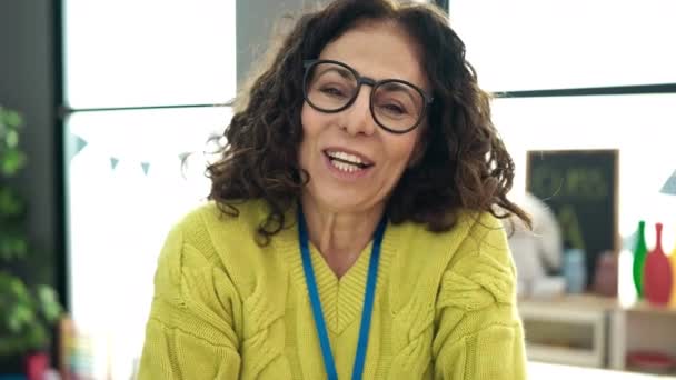 Middle Age Hispanic Woman Preschool Teacher Smiling Confident Speaking Kindergarten — Vídeos de Stock