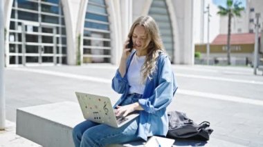 Üniversitede bilgisayarla konuşan sarışın bir kız öğrenci.