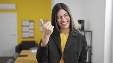 Genç, güzel İspanyol iş kadını güler yüzlü, kendine güvenen bir işadamı ofise gelip jest yapıyor.