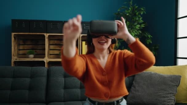 Молодая Рыжая Женщина Играет Видеоигры Используя Очки Виртуальной Реальности Дома — стоковое видео