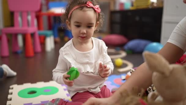 幼稚園の床に座って人形で遊んでいる女の子と教師 — ストック動画