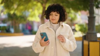 Young hispanic woman smiling confident making selfie by the smartphone at park