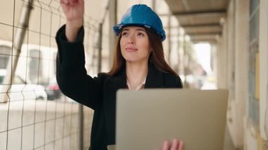 Sokakta dizüstü bilgisayar kullanan genç İspanyol bir mimar.